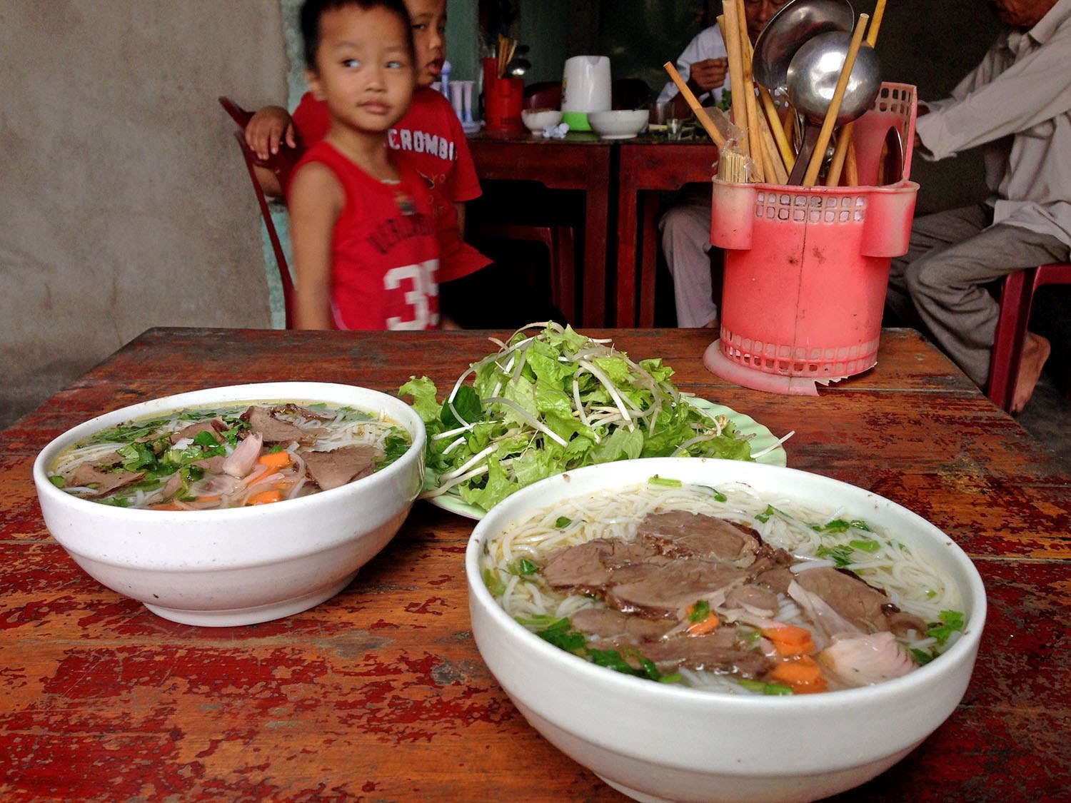 我们在一家小型家庭餐馆停下来，和店主的儿子们一起玩，他们正在准备我们的河粉。这是我们在越南吃过的最好吃的。